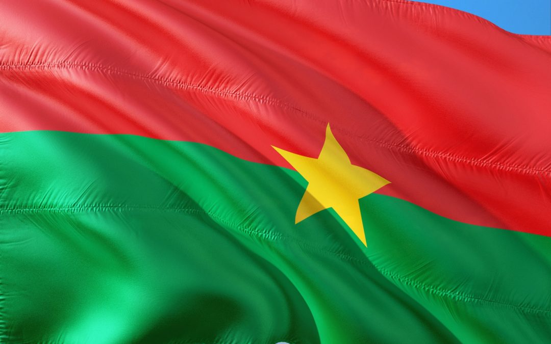 Flag of Burkina Faso blowing in the wind. Flag divided horizontally into a red side and green side with a yellow star in the centre of the flag.