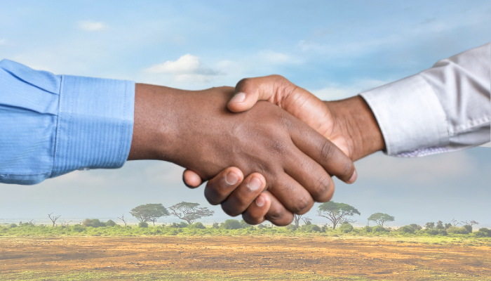 Decorative image showing photo of handshake between businessmen with faces out of the frame.