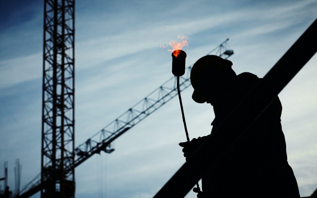 Silhouette of man in hardhat holding welding torch (photo)