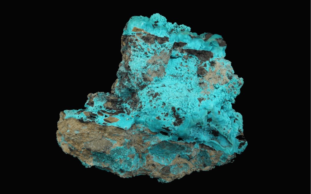 Copper deposits in a small piece of rock ore, against a plain black background.