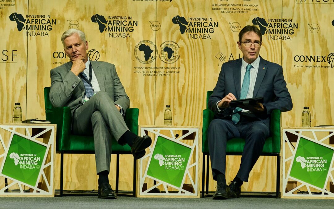 Photo showing two men in business suits - André de Ruyter and Roger Baxter - sitting in chairs on a stage at Mining Indaba in discussion