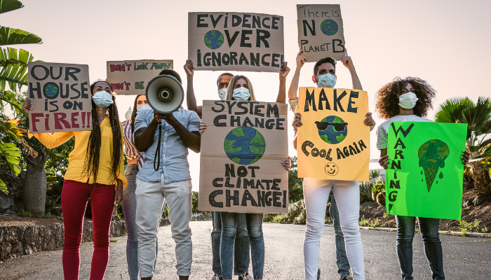 Group of young adults holding up signs protesting climate change
