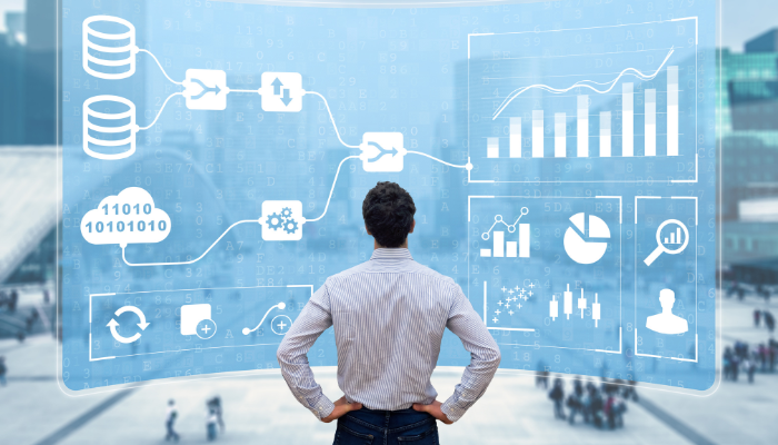 Man pictured from behind standing and looking at large visual representation of business analytics